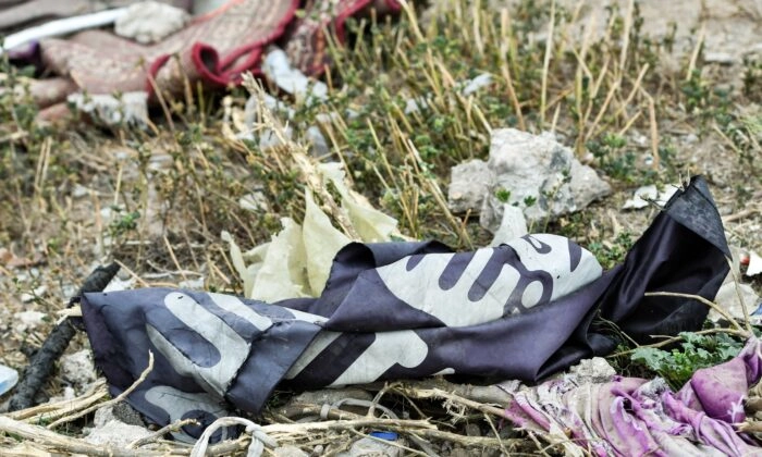 Una bandera descartada de ISIS tirada en el suelo en el pueblo de Baghouz en la provincia oriental siria de Deir Ezzor cerca de la frontera iraquí, el 24 de marzo de 2019. (Giuseppe Cacace/AFP vía Getty Images)