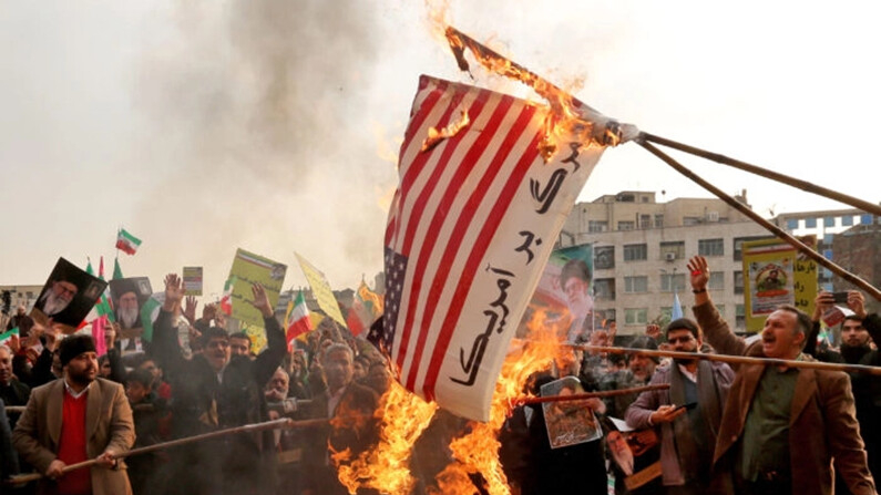 Manifestantes iraníes a favor del gobierno queman una bandera estadounidense improvisada, en Teherán, el 25 de noviembre de 2019. (Atta Kenare/AFP vía Getty Images)