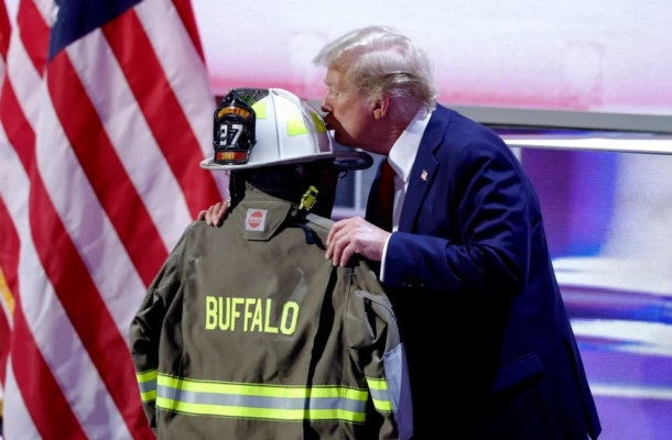 El expresidente y candidato presidencial republicano de 2024, Donald Trump, besa un casco y una chaqueta de bombero que pertenecieron a Corey Comperatore, quien recibió un disparo mortal en un mitin donde Trump sobrevivió a un intento de asesinato, tras aceptar la nominación de su partido en el último día de la Convención Nacional Republicana de 2024, en el Foro Fiserv en Milwaukee, Wisconsin. el 18 de julio de 2024. (Kamil Krzaczynski/AFP vía Getty Images)