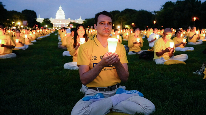 Practicantes de Falun Gong participan en una vigilia con velas en memoria de los practicantes de Falun Gong fallecidos durante los 25 años de persecución del Partido Comunista Chino en China, en el National Mall de Washington, el 11 de julio de 2024. Larry Dye/The Epoch Times)