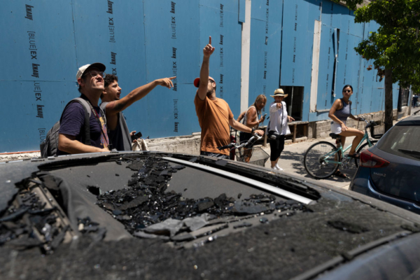 Varias personas observan un edificio dañado por la explosión de un dron, que los Houties de Yemen han reivindicado el 19 de julio de 2024 en Tel Aviv, Israel. (Amir Levy/Getty Images)