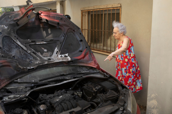 Una mujer señala un coche dañado por la explosión de un dron, que los Hutíes de Yemen han reivindicado el 19 de julio de 2024 en Tel Aviv, Israel. (Amir Levy/Getty Images)