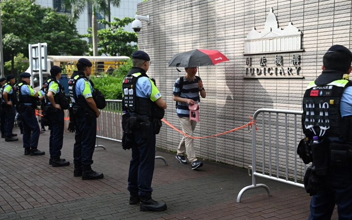 La policía observa a personas que ingresan a la Corte de Magistrados de West Kowloon, en Hong Kong, el 5 de julio de 2024, donde el activista pro democracia Joshua Wong y otras 5 personas comparecen para su sesión de descargos en el mayor caso contra activistas pro democracia conocidos como los 47, desde que China impuso una ley de seguridad nacional para reprimir la disidencia. (Peter PARKS / AFP vía Getty Images)
