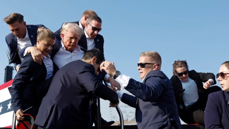 El expresidente Donald Trump es llevado fuera del escenario por agentes del Servicio Secreto de EE. UU. después de recibir un disparo durante un mitin en Butler, Pensilvania, el 13 de julio de 2024. (Anna Moneymaker/Getty Images)