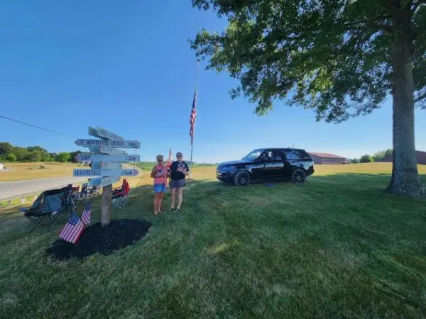 Sally Fox (izquierda) y su hija Hayle Fox presentan sus respetos a Corey Comperatore a lo largo de la ruta de su cortejo fúnebre cerca de Cabot, Pensilvania, el 19 de julio de 2024. (Jeff Louderback/Epoch Times)