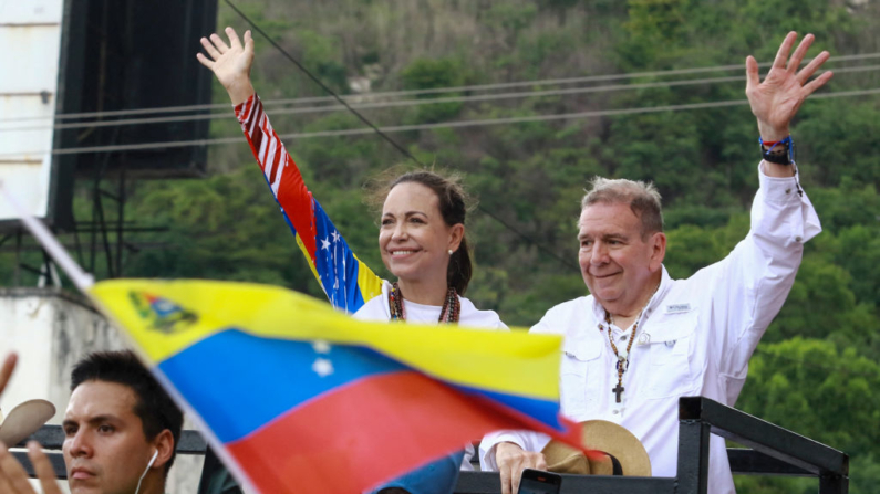 La líder opositora venezolana María Corina Machado y el candidato presidencial venezolano Edmundo González saludan a sus seguidores durante un acto de campaña en Valencia, estado de Carabobo, Venezuela, el 13 de julio de 2024. (Juan Carlos Hernandez/AFP vía Getty Images)