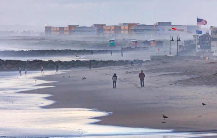 La gente camina por la playa durante la pausa de una tormenta invernal en Imperial Beach, California, el 1 de febrero de 2024. (John Fredricks/The Epoch Times)