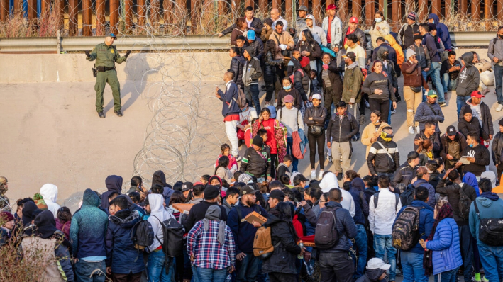 Un agente de la Patrulla Fronteriza de Estados Unidos habla con inmigrantes ilegales en El Paso, Texas, el 20 de diciembre de 2022. (John Moore/Getty Images)