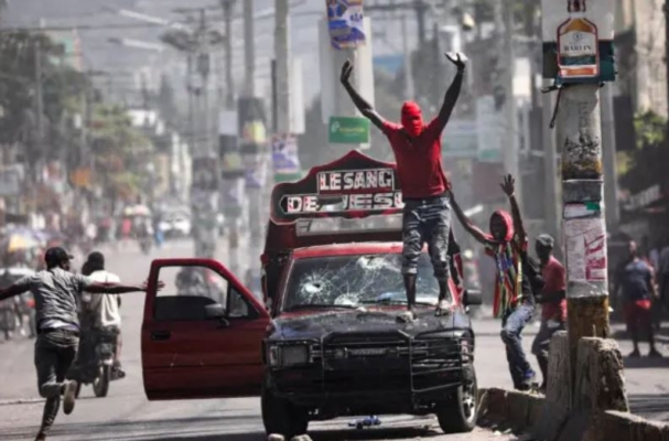 Un hombre con el rostro cubierto pide a los manifestantes que se detengan durante una protesta contra el gobierno del primer ministro Ariel Henry en Puerto Príncipe, Haití, el 1 de marzo de 2024. (Ralph Tedy Erol/Reuters)