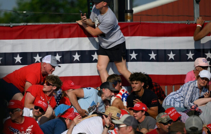 Los asistentes esquivan los disparos en un mitin de campaña del candidato presidencial republicano, el expresidente de Estados Unidos Donald Trump en Butler Farm Show Inc. en Butler, Pensilvania, el 13 de julio de 2024. (Jeff Swensen/Getty Images)
