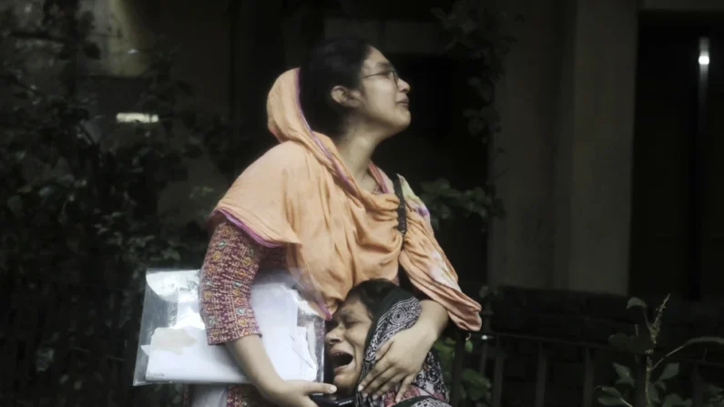 Sanjida, a la izquierda, consola a su madre, que se deshace en lágrimas tras recibir el cuerpo de su hijo, que fue baleado durante un choque entre policía y manifestantes, en una morgue en Daca, Bangladesh, el lunes 22 de julio de 2024. (AP Foto/Anik Rahman)