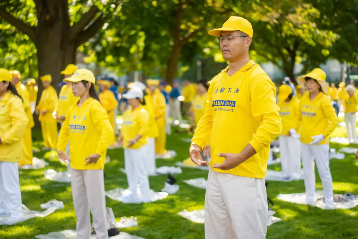 Practicantes de Falun Gong realizan sus ejercicios de meditación durante un acto celebrado en Queen's Park en Toronto, Ontario, el 20 de julio de 2024. El acto conmemora el 25 aniversario de la persecución de Falun Gong por el régimen chino. (Evan Ning/ The Epoch Times)