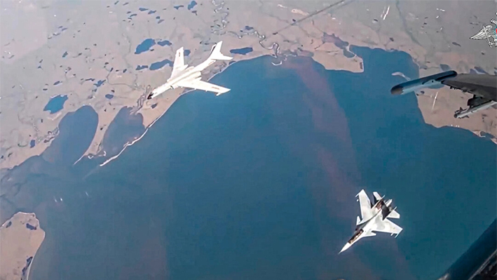 Un bombardero de largo alcance H-6K de la fuerza aérea china, arriba a la izquierda, es escoltado por un caza Su-30 de la fuerza aérea rusa durante una patrulla aérea conjunta Rusia-China en una imagen de un video publicado el 25 de julio de 2024. (Servicio de Prensa del Ministerio de Defensa ruso vía AP)
