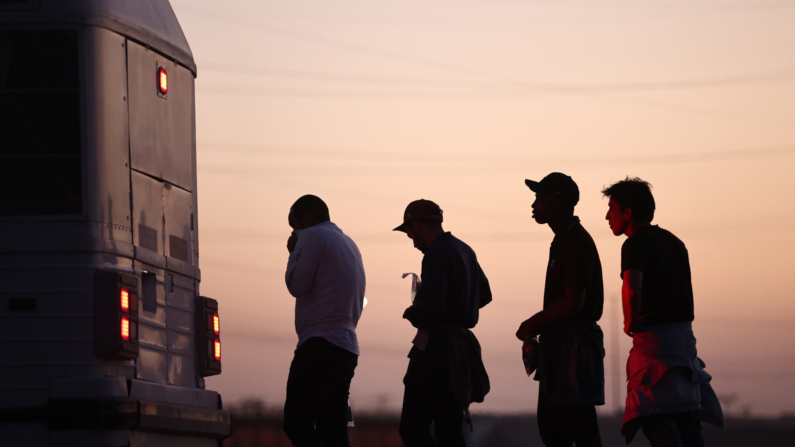  Inmigrantes que buscan asilo esperan para abordar un autobús hacia un centro de procesamiento de la Patrulla Fronteriza de EE. UU., después de cruzar a Arizona desde México, el 11 de mayo de 2023 en Yuma, Arizona. (Mario Tama/Getty Images)