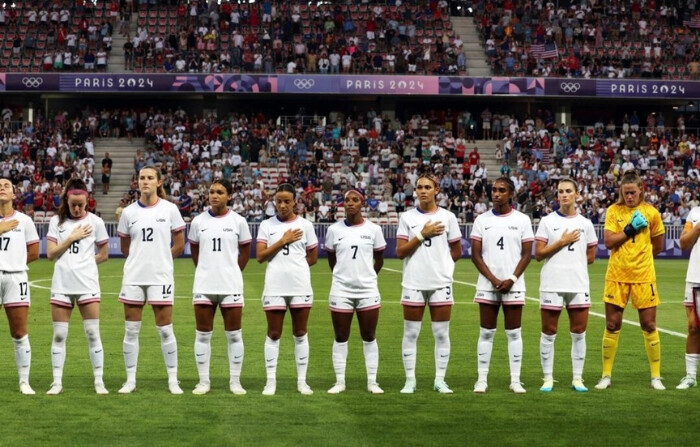 Miembros de la selección femenina de fútbol de Estados Unidos se alinean para los himnos nacionales antes de su primer partido olímpico contra Zambia en París el 25 de julio de 2024. (Raquel Cunha/Reuters)