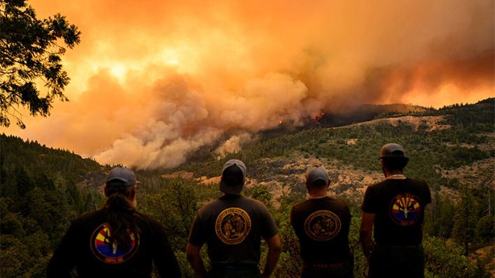 Los bomberos observan cómo las llamas y el humo se mueven a través de un valle en la zona de Forest Ranch del condado de Butte mientras el Park Fire continúa ardiendo cerca de Chico, California, el 26 de julio de 2024. (Josh Edelson/AFP vía Getty Images)
