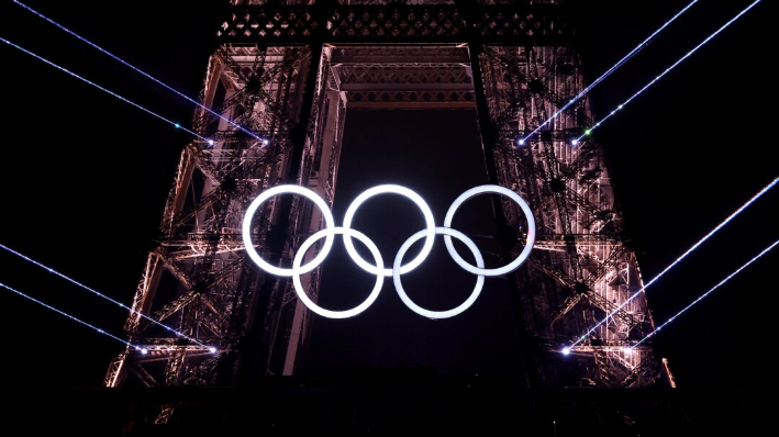 Un espectáculo de luces tiene lugar como Los Anillos Olímpicos en la Torre Eiffel se iluminan durante la ceremonia de apertura de los Juegos Olímpicos de París 2024 en la Place du Trocadero en París, Francia, el 26 de julio de 2024. (Hector Vivas/Getty Images)