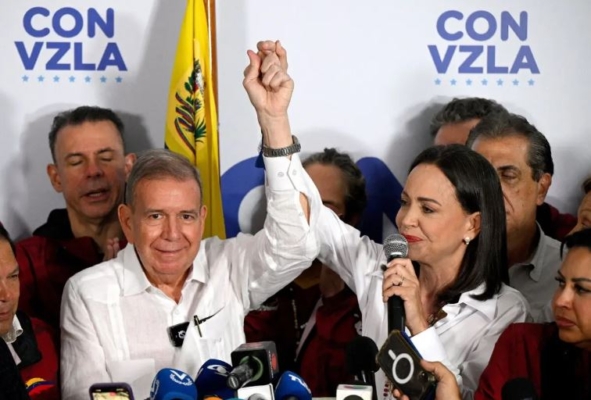 La líder opositora venezolana María Corina Machado (d) habla con los medios, acompañada por el candidato presidencial opositor Edmundo González Urrutia (i), tras los resultados de las elecciones presidenciales en Caracas, el 29 de julio de 2024. (Federico Parra/AFP vía Getty Images)