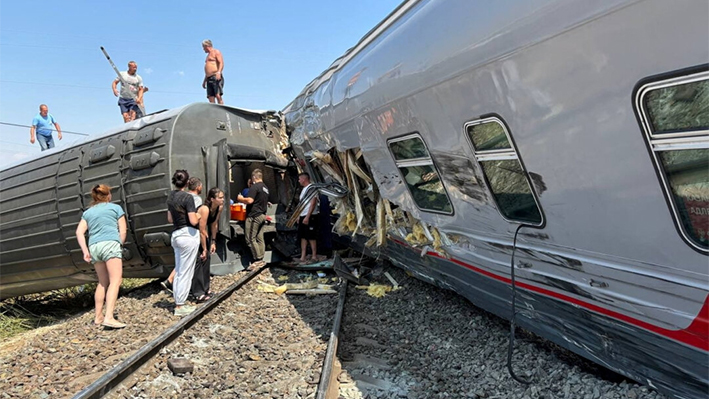 Una vista muestra a personas cerca de vagones descarrilados de un tren de pasajeros tras una colisión con un camión en la región de Volgogrado, Rusia, el 29 de julio de 2024. (Jefe del distrito municipal de Kotelnikovsky de la región de Volgogrado, Sergey Ponkratov, a través de Telegram/Handout via Reuters).