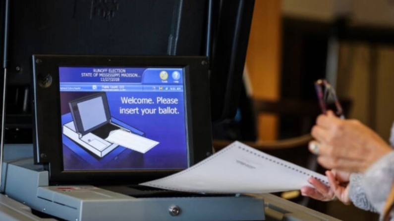 Una votante deposita su papeleta en un colegio electoral de la Iglesia Bautista Highland Colony en Ridgeland, Mississippi, el 27 de noviembre de 2018. (Drew Angerer/Getty Images)