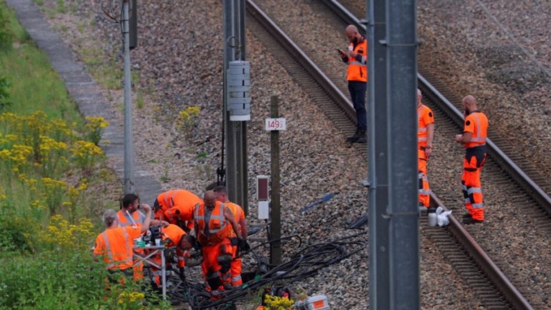 Empleados ferroviarios y agentes del orden trabajan en el lugar donde unos vándalos atacaron la red de trenes de alta velocidad de Francia con una serie de acciones coordinadas que provocaron importantes trastornos, en Croisilles, norte de Francia, el 26 de julio de 2024. (Brian Snyder/Reuters)