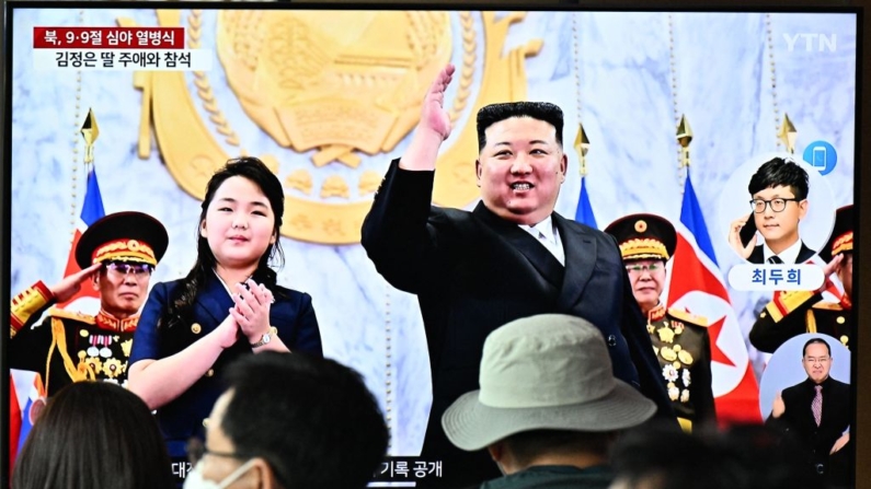 Varias personas se sientan frente a un televisor que muestra un noticiario con una foto del líder de Corea del Norte, Kim Jong-un (c), y su hija (i), que asisten a un desfile con motivo del 75 aniversario de la fundación del país, en una estación de tren en Seúl, el 9 de septiembre de 2023. (Anthony Wallace/AFP vía Getty Images)