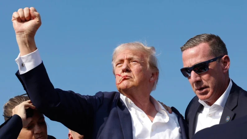 El candidato presidencial republicano, el expresidente Donald Trump, levanta el puño mientras lo sacan del escenario durante un mitin en Butler, Pensilvania, el 13 de julio de 2024. (Anna Moneymaker/Getty Images)