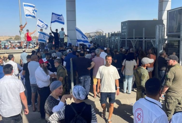 Manifestantes ondean banderas israelíes frente al centro de detención de Sde Teiman después de que la Policía Militar israelí llegara al lugar en el marco de una investigación por presuntos abusos a un detenido palestino, cerca de Beersheba, en el sur de Israel, 29 de julio de 2024. (Jill Gralow/Reuters)