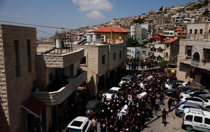 Los dolientes llevan ataúdes, durante el funeral de los niños que murieron en un campo de fútbol por un cohete que Israel afirma fue disparado desde el Líbano, en Majdal Shams, un pueblo druso en los Altos del Golán, bajo ocupación de Israel, el 28 de julio de 2024. (Ammar Awad/Reuters)