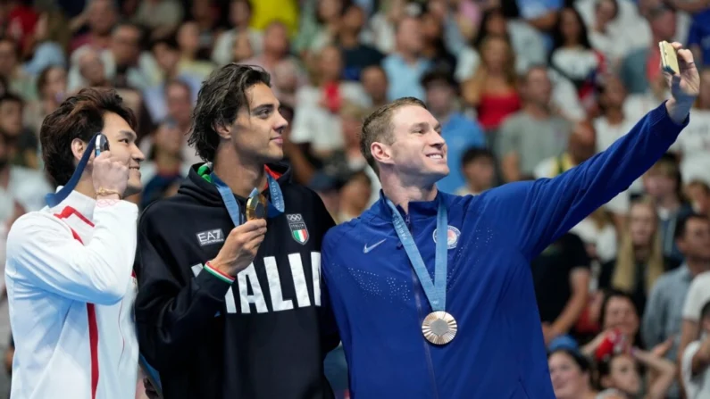 El medallista de oro Thomas Ceccon, de Italia, se encuentra en el podio con el medallista de plata Xu Jiayu (izq.) de China y el medallista de bronce Ryan Murphy (der.) de Estados Unidos, para una selfie después de la final masculina de 100 metros espalda en los Juegos Olímpicos de Verano de 2024 en Nanterre, Francia, el 29 de julio de 2024. (Matthias Schrader/AP Foto)