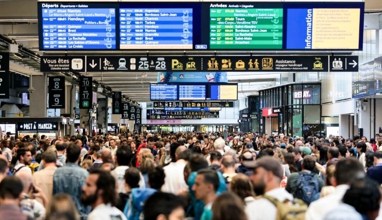 Los pasajeros se reúnen alrededor de los tableros de salida y llegada en la estación de tren Gare Montparnasse en París, Francia, el 26 de julio de 2024. (Thibaud Moritz/AFP vía Getty Images)