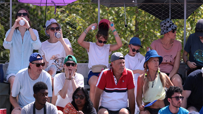 Espectadores usan paraguas para protegerse del sol durante la segunda ronda de individuales masculinos entre Lorenzo Musetti de Italia y Mariano Navone de Argentina en el Estadio Garros, París, el 30 de julio de 2024. (Claudia Greco/Reuters)
