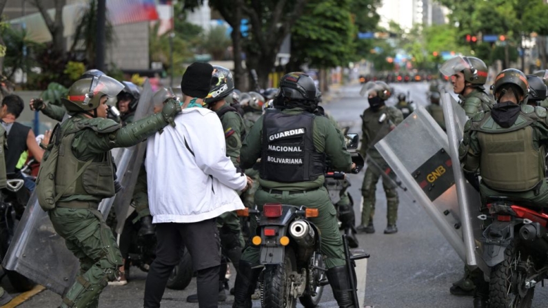 Miembros del escuadrón antidisturbios de la Guardia Nacional Bolivariana (GNB) detienen a opositores al líder venezolano Nicolás Maduro que participaban en una manifestación, en el barrio de Chacao, en Caracas, el 30 de julio de 2024. (Yuri Cortez/AFP vía Getty Images)