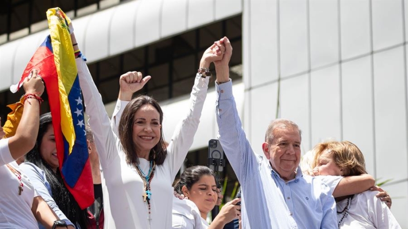 La líder opositora venezolana María Corina Machado (i) y el candidato a la presidencia de Venezuela Edmundo González Urrutia saludan en una manifestación contra el resultado de las elecciones presidenciales del 30 de julio de 2024, en Caracas (Venezuela). EFE/ Ronald Peña R.