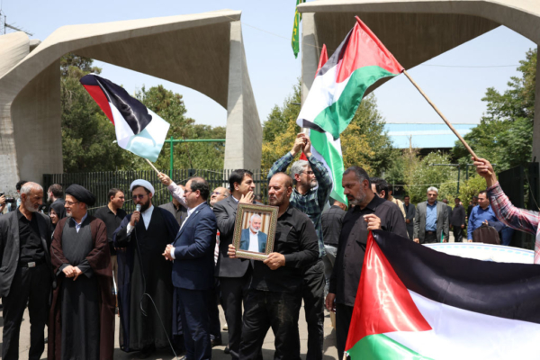 Unas personas sostienen la bandera palestina y un retrato del jefe de Hamás asesinado Ismail Haniyeh, durante una manifestación en la Universidad de Teherán, en la capital iraní Teherán el 31 de julio 2024, luego que Irán declarara tres días de luto. (Foto de AFP/ vía Getty Images)