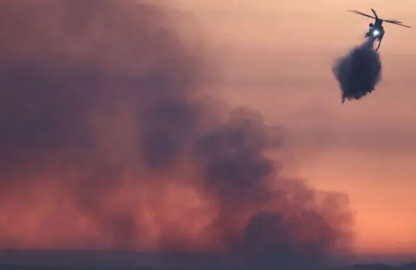 Un helicóptero de bomberos lanza agua mientras el incendio Nixon arde cerca de Aguanga del condado de Riverside, California, el 29 de julio de 2024. (Mario Tama/Getty Images)