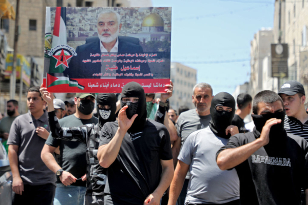 Palestinos llevan una pancarta con la imagen del líder de Hamás, Ismail Haniyeh, en la ciudad de Hebrón, en Cisjordania, el 31 de julio de 2024, (Mosab Shawer/AFP vía Getty Images)