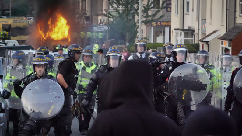 Policías antidisturbios contienen a manifestantes después de que estallaran disturbios el 30 de julio de 2024 en Southport, Inglaterra. Los rumores sobre la identidad del joven de 17 años sospechoso del ataque mortal con arma blanca de ayer en esta localidad desencadenó una violenta protesta. (Getty Images/Getty Images)