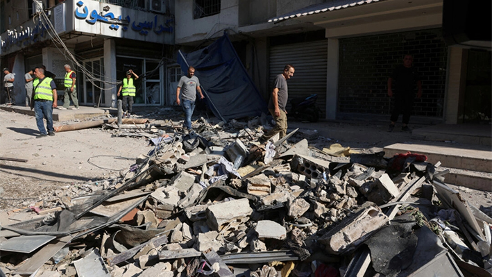 Personas caminan sobre los escombros de un lugar dañado el día después de un ataque israelí, en los suburbios del sur de Beirut, Líbano, el 31 de julio de 2024. (Mohamed Azakir/Reuters)
