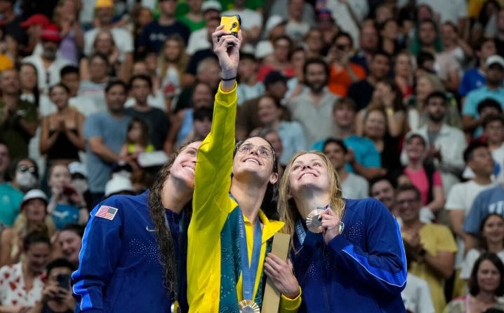 La nadadora australiana Kaylee McKeown (C), medalla de oro, junto a la estadounidense Regan Smith (D), medalla de plata, y la estadounidense Katherine Berkoff, medalla de bronce, en el podio tras la final femenina de los 100 metros estilo espalda en los Juegos Olímpicos de Nanterre, Francia, el 30 de julio de 2024. (Matthias Schrader/Foto AP)