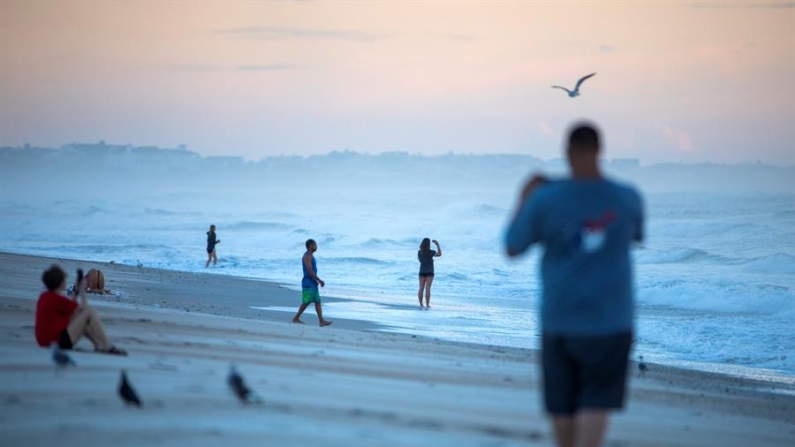 Fotografía de archivo en donde se observa a varias personas tomando fotografías al amanecer. EFE/ Jim Lo Scalzo