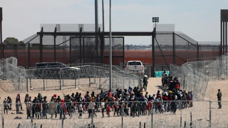 Inmigrantes ilegales hacen fila para ser trasladados por la Patrulla Fronteriza de Estados Unidos después de haber cruzado el río Bravo en El Paso, Texas, visto desde Ciudad Juárez, estado de Chihuahua, México, el 18 de abril de 2024. (Herika Martinez/AFP vía Getty Images)
