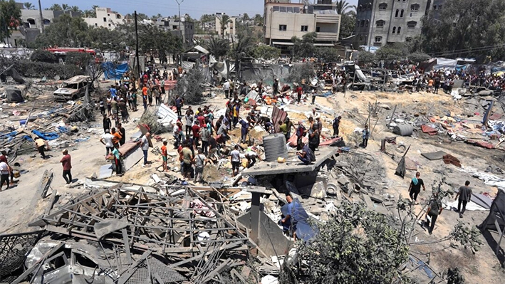 Habitantes de Gaza observan los escombros de tiendas de campaña y estructuras de alojamiento improvisadas destruidas tras un ataque militar israelí contra el campo de desplazados internos de al-Mawasi, cerca de la ciudad de Jan Yunis, en el sur de la Franja de Gaza, el 13 de julio de 2024. (Bashar Taleb/AFP vía Getty Images)