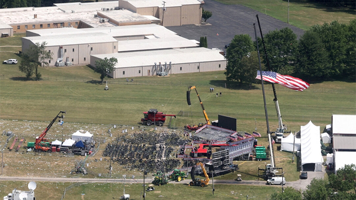 El escenario donde se encontraba el expresidente Donald Trump durante un intento de asesinato el día anterior, y el tejado de un edificio cercano donde un hombre armado fue abatido por las fuerzas del orden, en Butler, Pensilvania, el 14 de julio de 2024. (Brendan McDermid/Reuters)