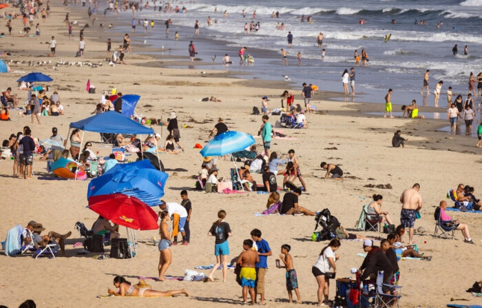 Los bañistas disfrutan del sol en Huntington Beach, California, el 19 de junio de 2024. (John Fredricks/The Epoch Times)
