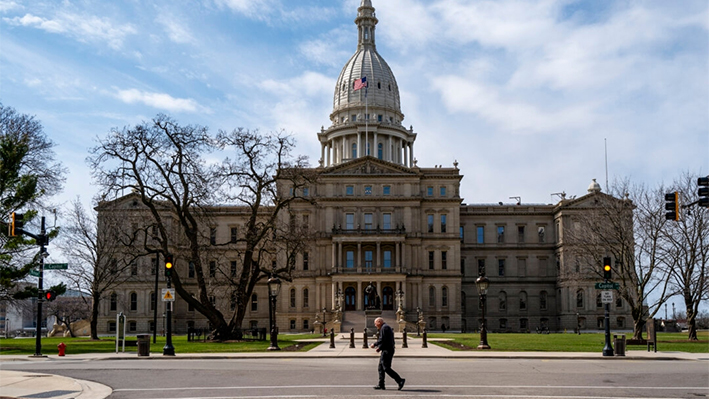 Un hombre cruza la calle frente al edificio del Capitolio del Estado de Michigan en Lansing, Michigan, el 1 de abril de 2024. (Spencer Platt/Getty Images)
