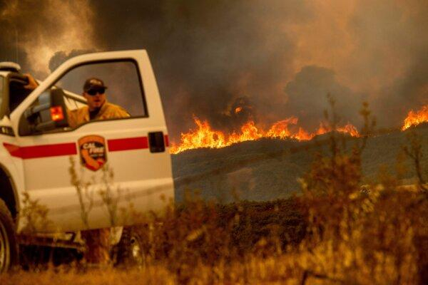 El Ranch Fire, parte del incendio del Complejo Mendocino, cresta una cresta mientras el jefe de batallón Matt Sully dirige las operaciones de extinción de incendios en High Valley Rd. cerca de Clearlake Oaks, California, el 5 de agosto de 2018. (Noah Berger/AFP vía Getty Images)