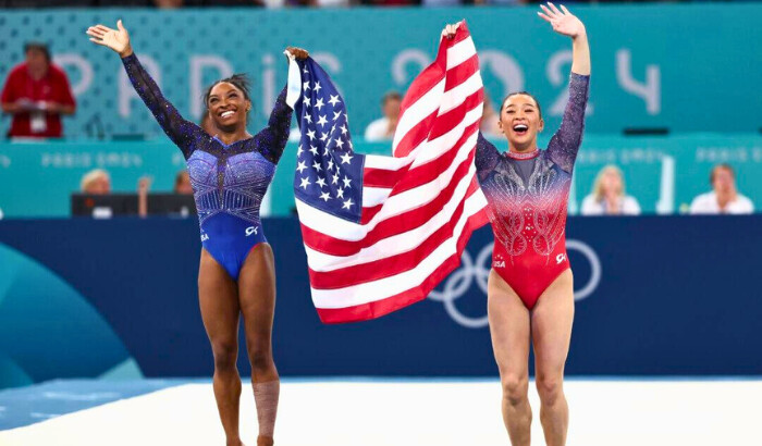 La medallista de oro Simone Biles (izq.) y la medallista de bronce Sunisa Lee, del equipo de Estados Unidos, celebran con la bandera estadounidense después de competir en la final femenina de gimnasia artística en el sexto día de los Juegos Olímpicos de París 2024 en el Bercy Arena de París el 1 de agosto de 2024. (Naomi Baker/Getty Images)