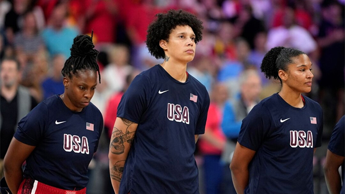 Brittney Griner (C), del equipo de Estados Unidos, se pone en pie para escuchar el himno nacional antes de un partido contra Bélgica en los Juegos Olímpicos de Villeneuve-d'Ascq, Francia, el 1 de agosto de 2024. (Michael Conroy/Foto AP)