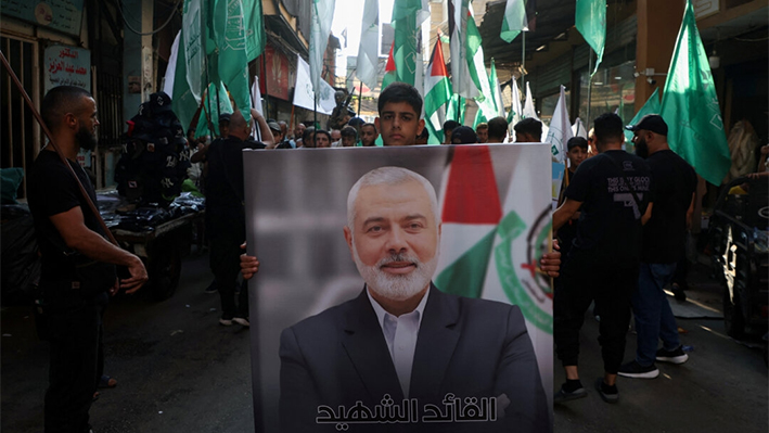 Un palestino lleva una foto del difunto líder de Hamás Ismail Haniyeh, asesinado en Irán, durante una marcha para condenar su asesinato, en el campo de refugiados palestinos de Burj al-Barajneh, en Beirut, Líbano, el 31 de julio de 2024. (Mohamed Azakir/Reuters)